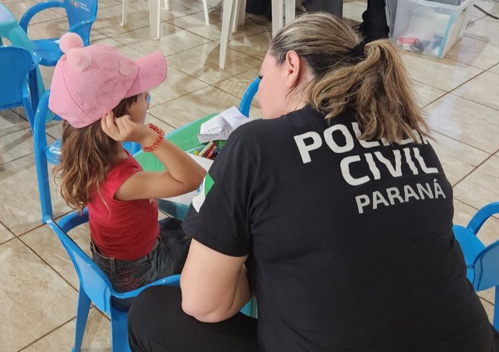 policial civil mulher conversa com criança usando boné rosa
