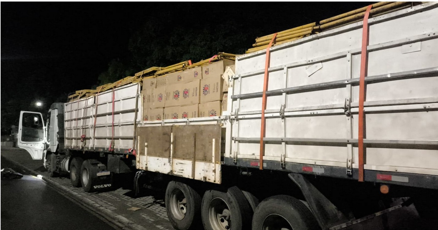 A Polícia Militar do Paraná (PMPR), por meio do 3º Batalhão de Polícia Militar (BPM), apreendeu, na noite deste domingo (12), uma carga de cigarros contrabandeados em Pato Branco, no Sudoeste do Estado.  A ação ocorreu durante bloqueio policial no trevo de acesso ao município, na rodovia PRC-158, quando os policiais abordaram um caminhão trator acoplado a um semirreboque.  Durante a vistoria no compartimento de carga, as equipes visualizaram, por meio das aberturas de escoamento, caixas de papelão contendo 