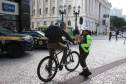 Ciclistas e pedestres da XV de Novembro, em Curitiba, recebem materiais educativos do trânsito