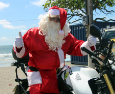  PM promove ação de Natal e encanta veranistas com entrega de doces e pintura de rosto em Guaratuba (PR), no Litoral do estado 