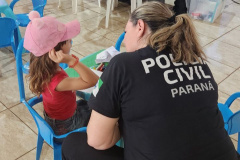 policial civil mulher conversa com criança usando boné rosa
