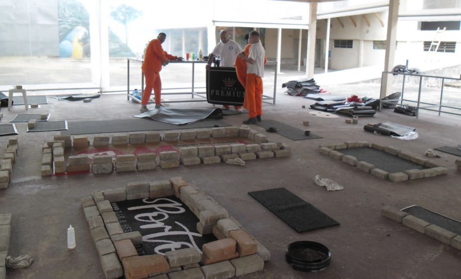 O Departamento Penitenciário do Paraná (Depen) assinou dois convênios com empresas privadas para empregar 36 detentos da Penitenciária Central do Estado – Unidade de Progressão (PCE-UP), localizada em Piraquara, na Região Metropolitana de Curitiba (RMC). Há cerca de um mês, tapetes higiênicos para cães e capachos estão sendo fabricados com mão de obra carcerária. A unidade também recebeu diversas melhorias estruturais, como pavimentação e novos espaços construídos pelos detentos.