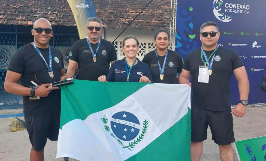 Policiais paranaenses com bandeira do Paraná na Paralimpíadas