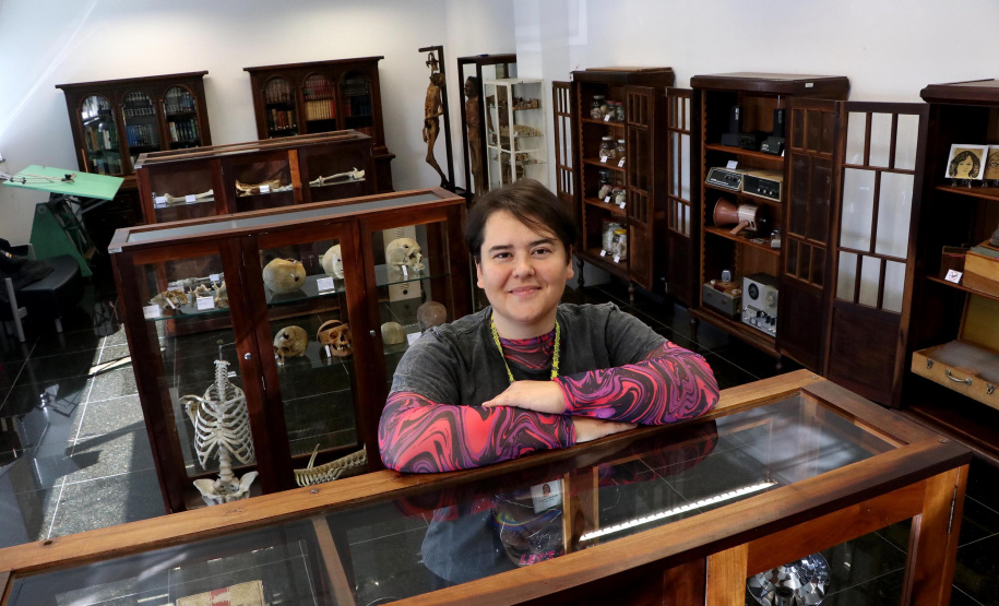 diretora do Museu Paranaense de Ciências Forenses, Fabíola Schutzenberger, em frente ao acervo